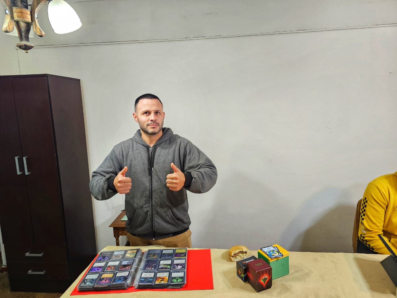 Un jugador mostrando su carpeta de cartas con los pulgares arriba