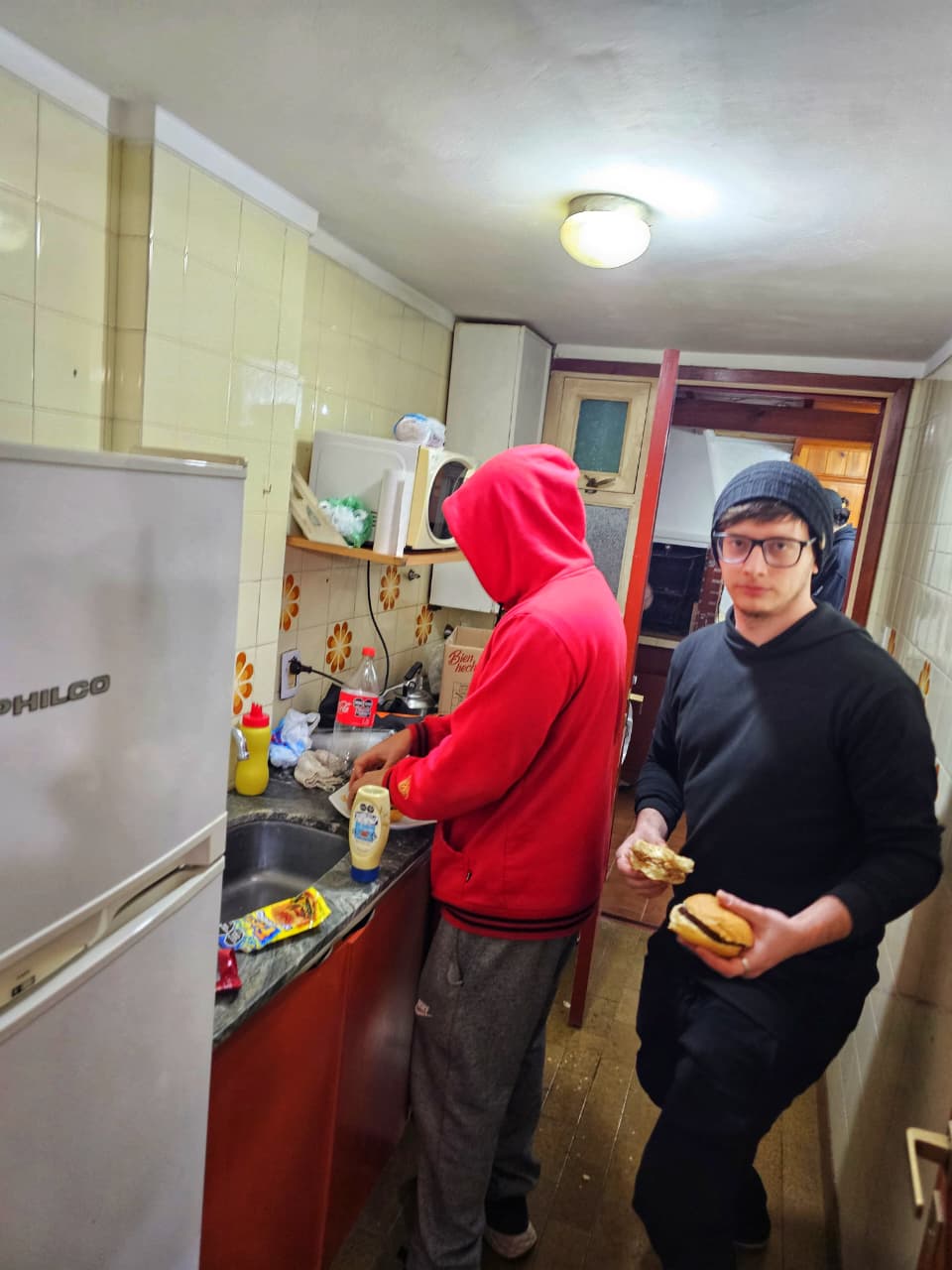 Dos jugadores en la cocina preparando hamburguesas entre rondas